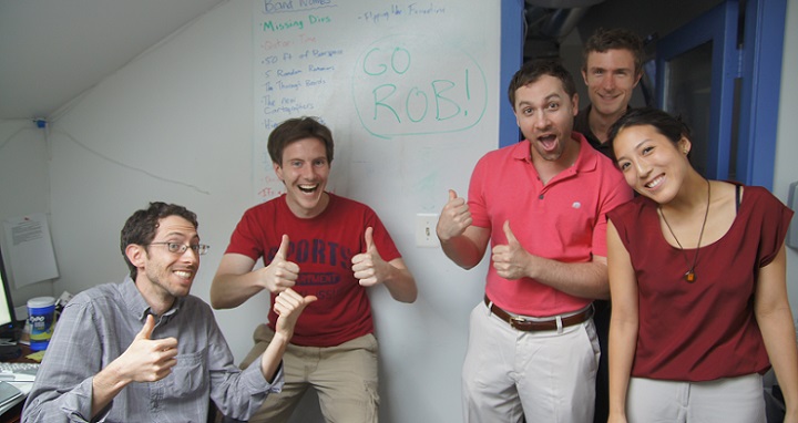 Photo of TechChange Staff next to a sign congratulating Rob Baker