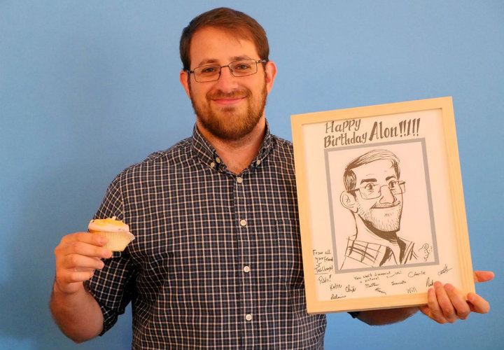 Alon with his birthday gifts from the office: cupcakes and a sketch of himself made by his co-worker Pablo